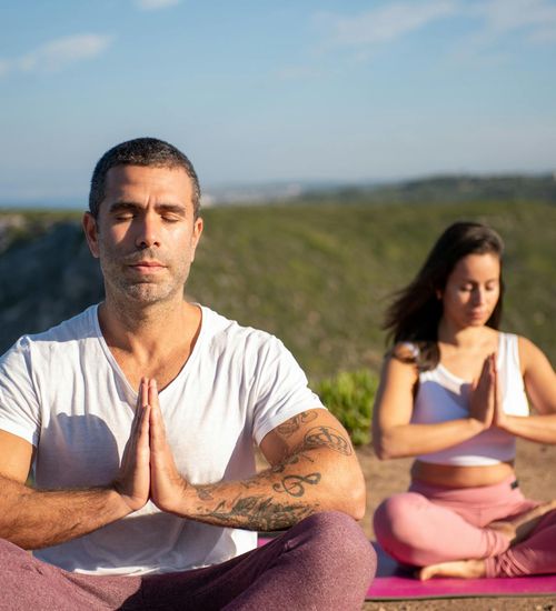Man meditating on a yoga mat with a serene expression.